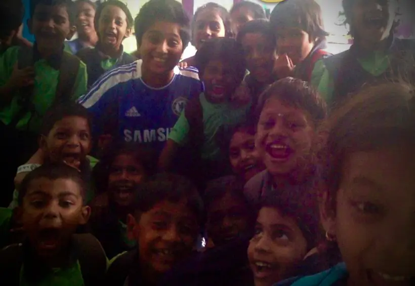 A crowd of school children packed into frame, all grinning