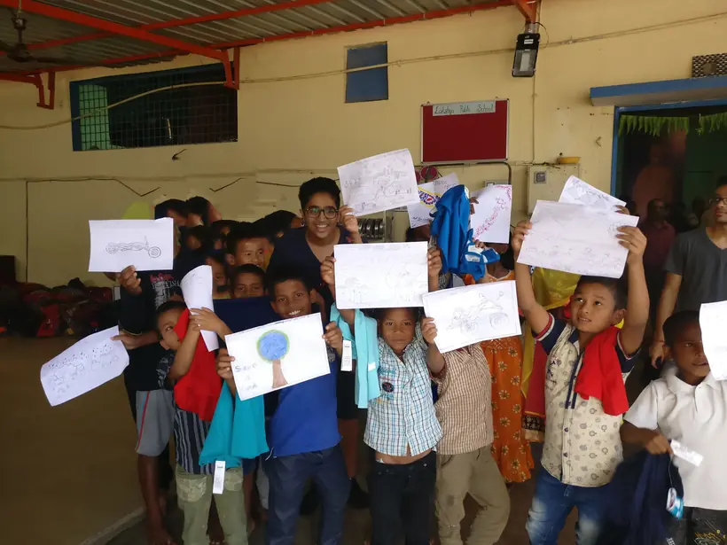 A room of children holding up drawings they have made